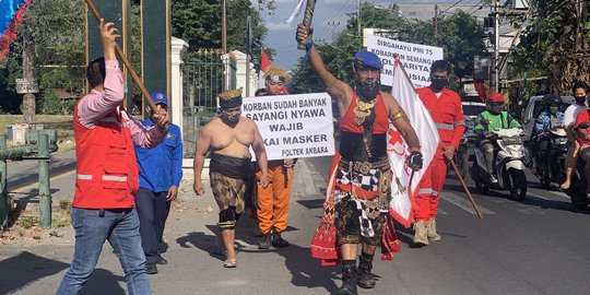 Berkostum Bima, Kopral Bagyo Berlari sambil Bagikan Masker