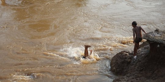 Kenekatan Anak-Anak Berenang di Tengah Aliran Deras Sungai Ciliwung