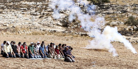 Potret Warga Palestina Salat di Tengah Tembakan Gas Air Mata Israel