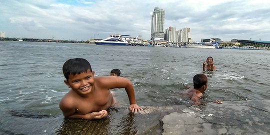 Keceriaan Anak Pesisir Berenang saat Banjir Rob di Pelabuhan Kali Adem