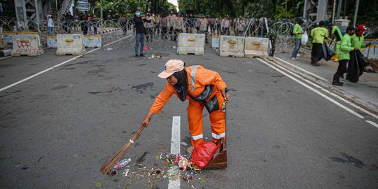 Aksi Petugas Bersihkan Sampah Massa Unjuk Rasa di Sekitaran Patung Kuda