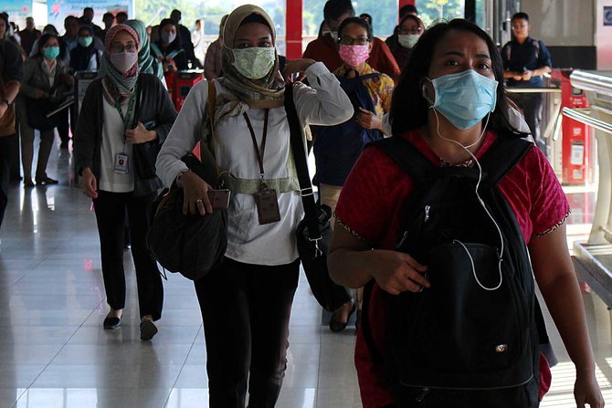 warga memakai masker di stasiun palmerah