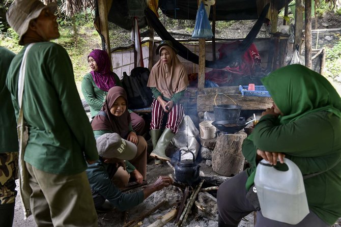 para penjaga hutan mpu uteun mengisi kembali tenaga dengan membuat makanan dan minuman hangat