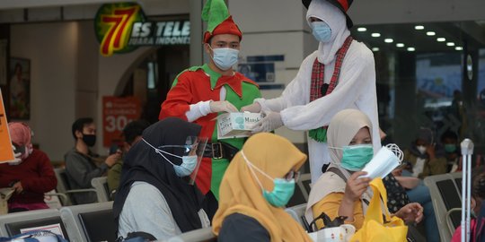 Berbaju Santa, Petugas KAI Bagikan Masker ke Penumpang