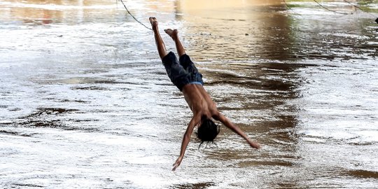 Aksi Nekat Anak-Anak Lompat ke Sungai Ciliwung yang Meluap