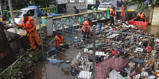 Aksi Petugas UPK Badan Air DLH DKI Bersihkan Sumbatan Sampah di Kali Mampang