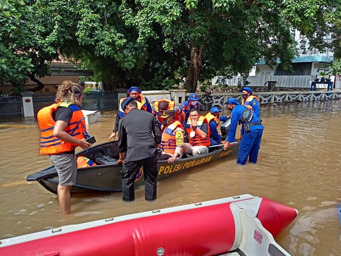 personel polri membantu evakuasi warga korban banjir jakarta dan bekasi