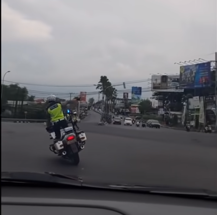 polisi patwal atraksi di atas motor saat mengawal