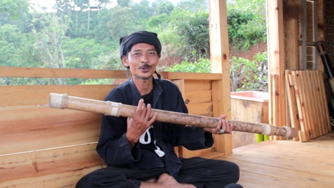 ki madhari sedang memainkan bambu sebagai kesenian di desa citengah sumedang