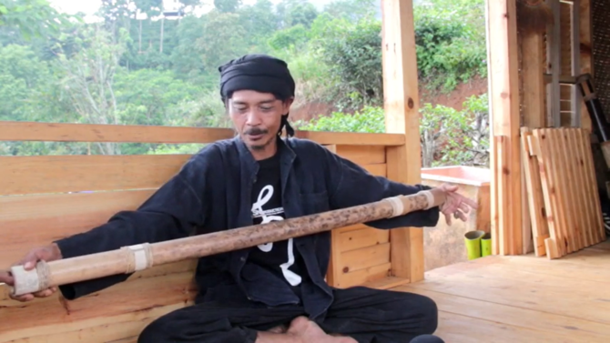 ki madhari sedang memainkan bambu sebagai kesenian di desa citengah sumedang