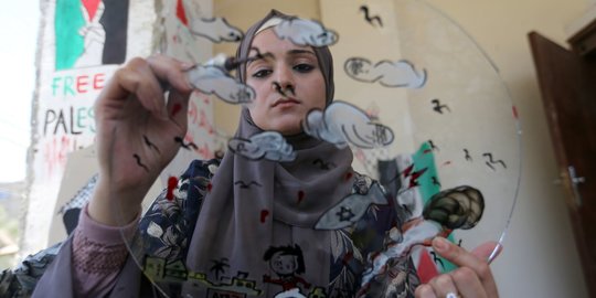 Kreativitas Seniman Cantik Palestina Melukis Karyanya di Atas Puing
