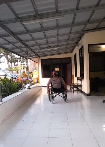 hidup tanpa dua kaki polisi ini tetap semangat bertugas meski di atas kursi roda