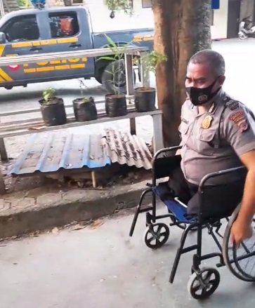 hidup tanpa dua kaki polisi ini tetap semangat bertugas meski di atas kursi roda