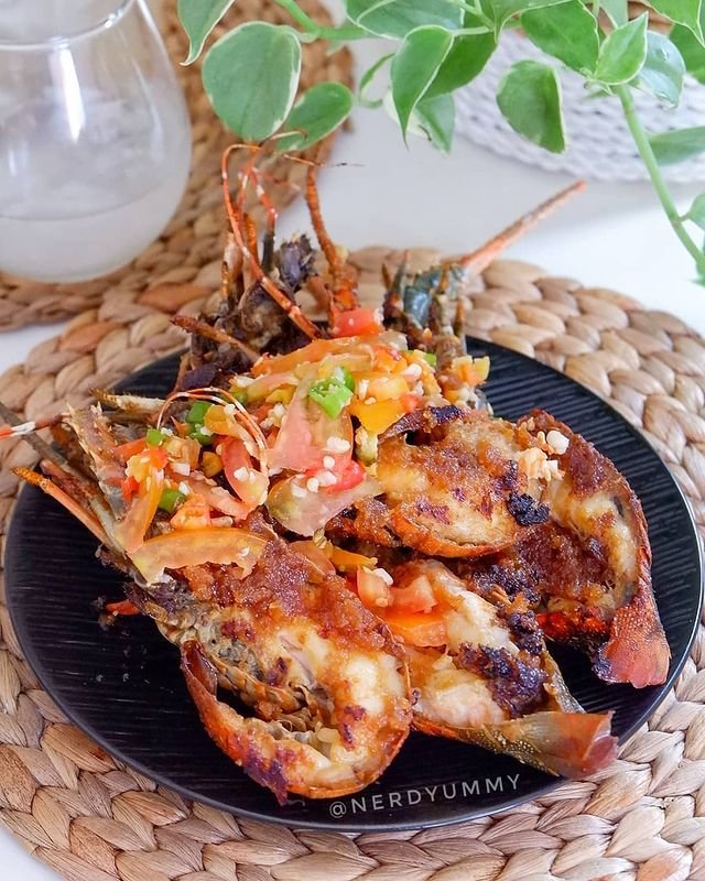  /></p>
<p><em>©2021 Merdeka.com/</em>Instagram/@nerdyummy</p>
<p>Bahan:</p>
<ul>
<li>1/2 kg lobster</li>
<li>1 cm terasi</li>
<li>Garam</li>
<li>Gula</li>
<li>1 sdm saus tiram</li>
<li>1 sdm saus tomat</li>
<li>1 sdm saus cabai</li>
</ul>
<p>Bumbu halus:</p>
<ul>
<li>4 siung bawang putih</li>
<li>1/2 bawang bombay besar</li>
<li>Minyak secukupnya</li>
</ul>
<p>Sambal:</p>
<ul>
<li>1 siung bawang putih cincang halus</li>
<li>5 cabai rawit</li>
<li>5 cabai hijau</li>
<li>1/2 tomat besar</li>
<li>Garam</li>
<li>Gula</li>
</ul>
<p>Cara membuat:</p>
<ul>
<li>Bersihkan dan belah lobster jadi 2.</li>
<li>Haluskan bumbu halus, tumis hingga wangi.</li>
<li>Tambahkan saus tiram, saus tomat, dan saus cabai. Bumbui dengan garam dan gula. Masak hingga matang.</li>
<li>Letakan lobster di grill pan yang panas.</li>
<li>Oleskan bumbu pada bagian daging, tunggu hingga cangkang berubah merah.</li>
<li>Balik lobster dan masak sekitar 5 menit atau hingga matang.</li>
<li>Buat sambal dengan cincang halus bawang, tambahkan cabai dan tomat yang diiris tipis. Bumbui dengan garam dan gula. Sajikan di atas lobster bakar.</li>
</ul>
<p><strong>Resep Lobster Bakar Saus Mentai</strong></p>
<p><img src=