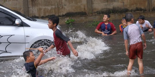 Ketika Banjir Jadi Arena Bermain Anak-Anak