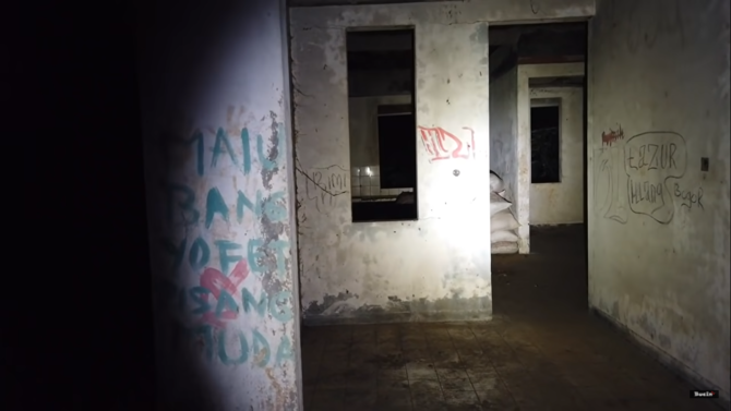 rumah dua lantai di tengah kuburan