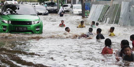 Anak-Anak Bermain Air saat Banjir Merendam Jalan Bungur Besar Raya