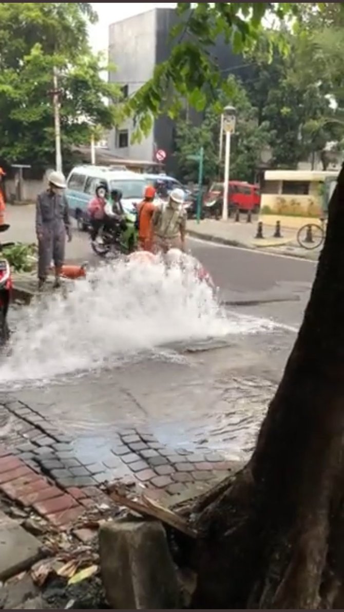 aksi pria cuci motor di samping pipa bocor