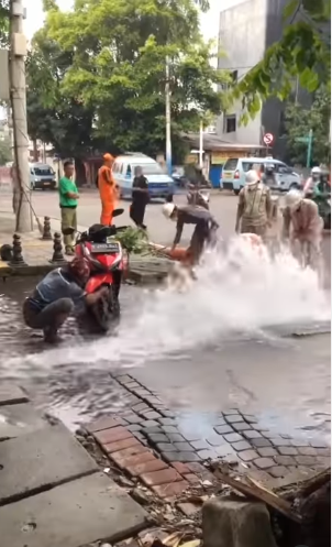 air pdam bocor dan berhamburan ke jalan bapak ini asyik nyuci motor