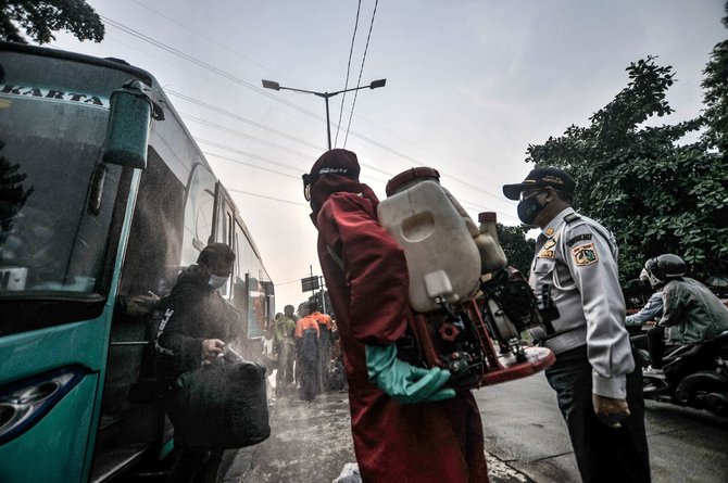 penyemprotan disinfektan kepada pemudik di terminal kampung rambutan