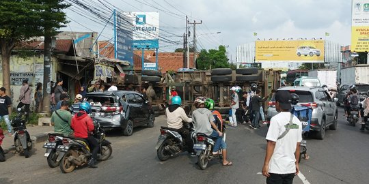 Truk Kontainer Diduga Rem Blong Terguling Usai Seruduk Mobil dan Warung