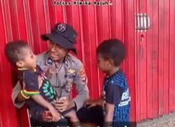 di momen hut bhayangkara ke 76 polisi ini gendong anak papua dengan tersenyum