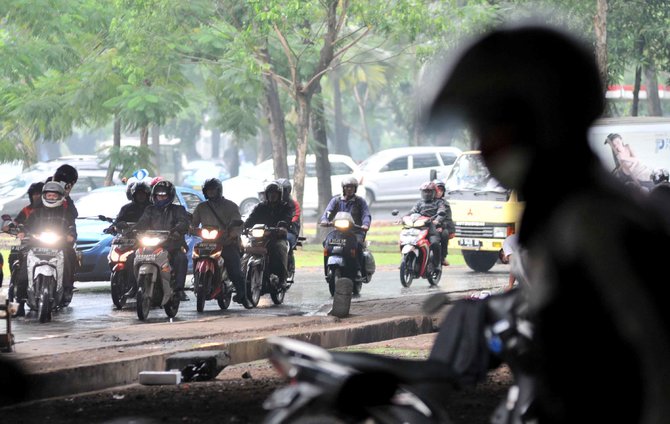 pengendara sepeda motor terjebak hujan