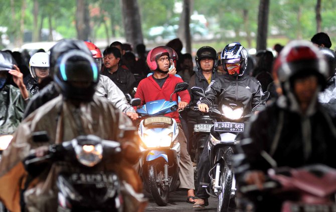 pengendara sepeda motor terjebak hujan