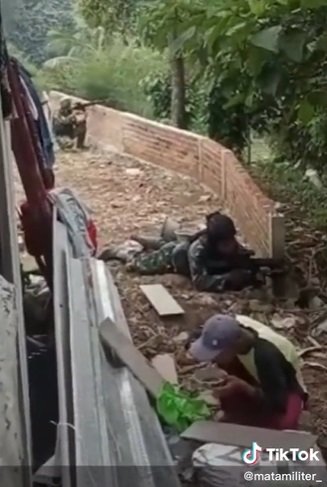 pria asyik santai makan di samping para tentara yang adu tembak sikapnya bikin heran