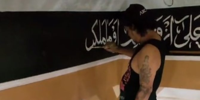Mahir Tulis Kaligrafi di Tembok Masjid, Aksi Laki-laki Bertato Ini Jadi Sorotan