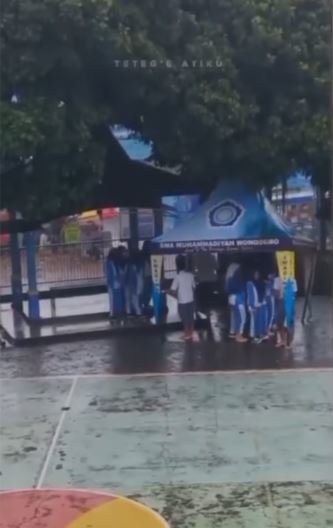 unik sekumpulan pria sma pakai tenda untuk bantu temannya lewati hujan