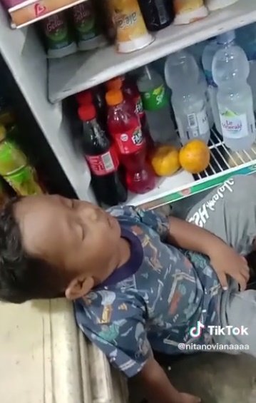 anak kecil tidur depan kulkas