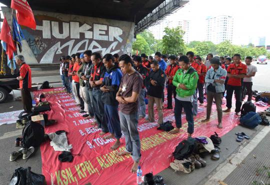 Demonstran salat Jumat di kolong jembatan Senayan