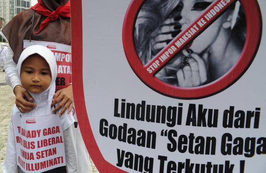 Seorang demonstran membawa poster penolakan konser Lady Gaga pada aksi 