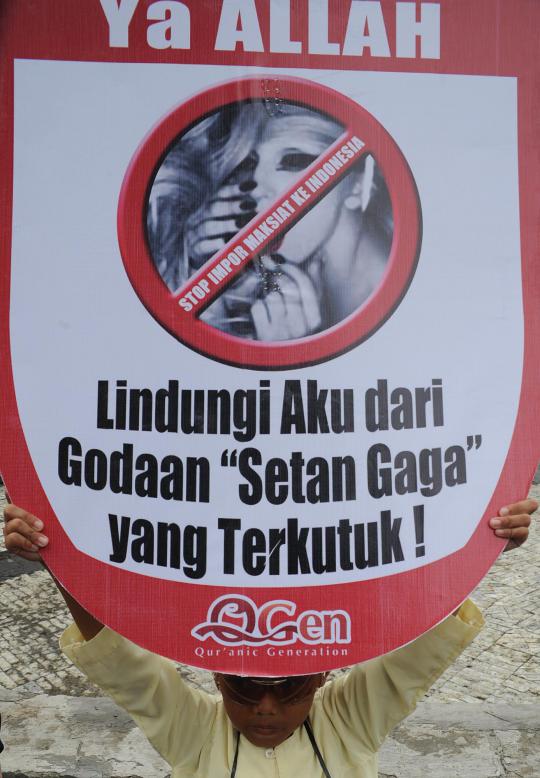Seorang demonstran membawa poster penolakan konser Lady Gaga pada aksi 