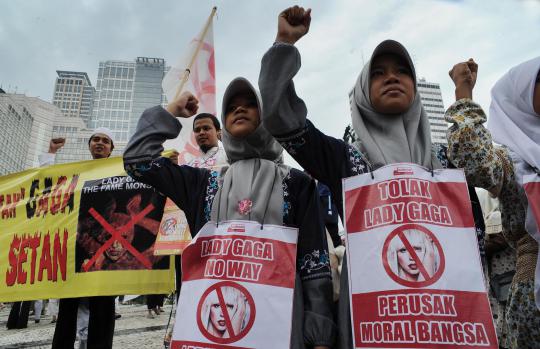 Seorang demonstran membawa poster penolakan konser Lady Gaga pada aksi 