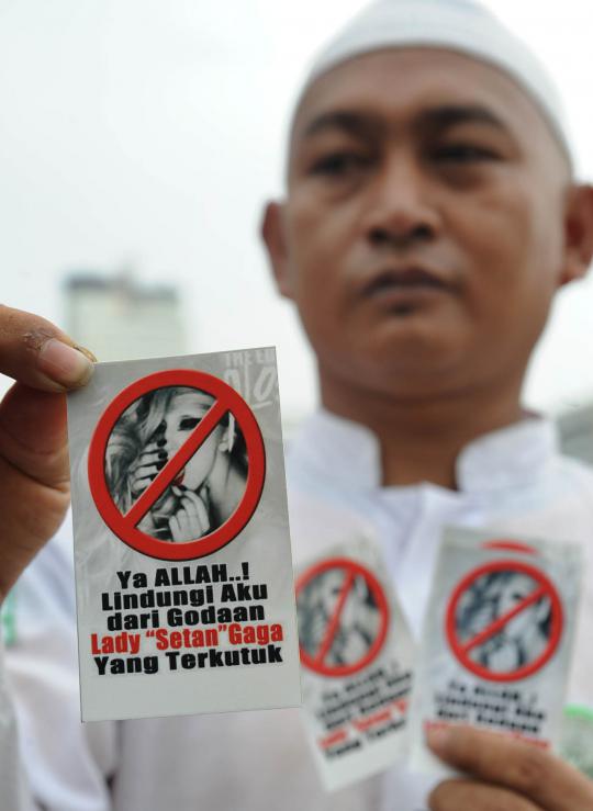 Seorang demonstran membawa poster penolakan konser Lady Gaga pada aksi 
