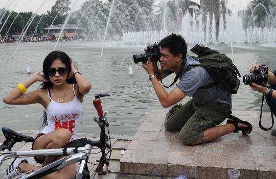 Sejumlah fotografer amatir saling mengambil gambar model yang berpose  