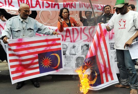 Pengunjuk rasa yang tergabung dalam Aktivis Bendera membakar  bendera  