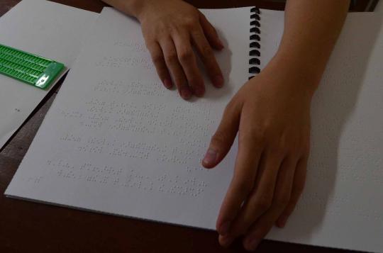 Siswa SLB mengerjakan soal ujian nasional dengan menggunakan huruf bra 