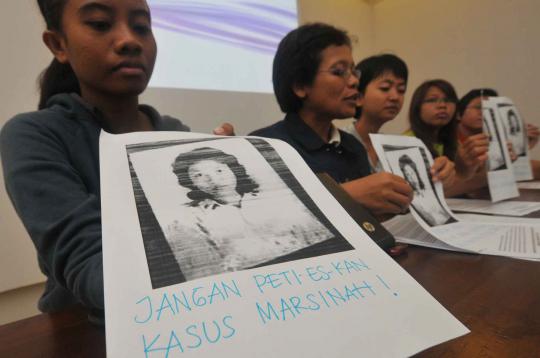 Seorang aktivis menuliskan pesan di foto Marsinah saat konferensi pers 