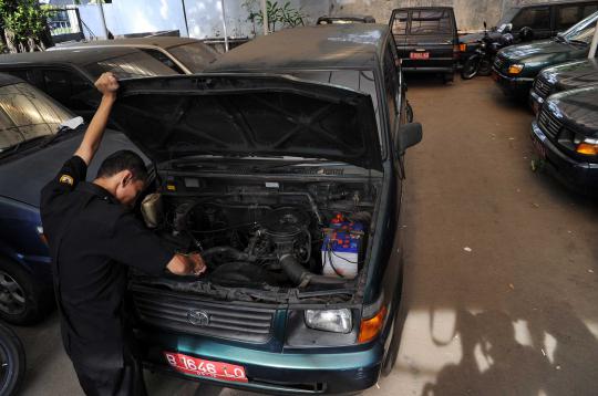 Petugas KPU memeriksa mesin kendaraan yang akan dilelang di kantor KPU 