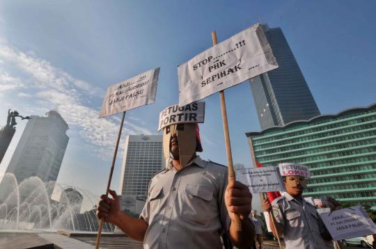 Salah satu petugas Portir dari pekerja PT KAI membawa poster saat demo 