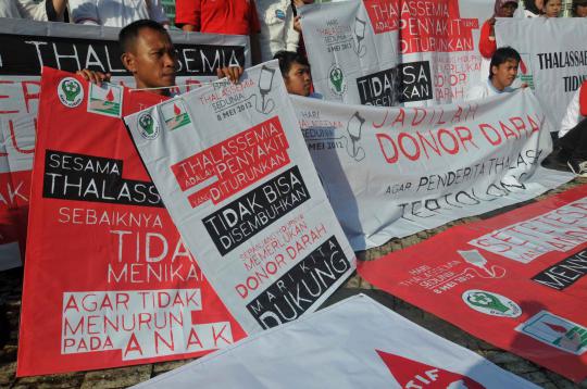 Aktivis membawa poster yang berisikan pesan kepada masyarakat  dalam r 