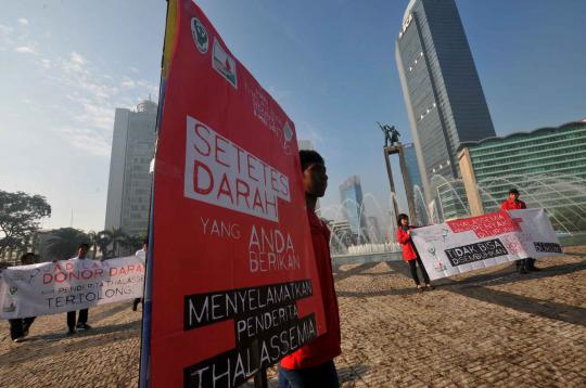 Aktivis membawa poster yang berisikan pesan kepada masyarakat  dalam r 