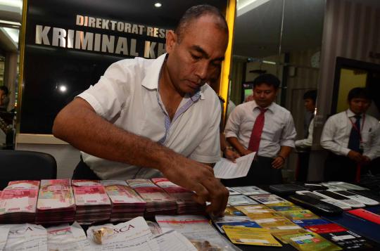 Petugas kepolisan sedang memeriksa barang bukit hasil kejahatan para p 