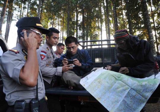 Petugas SAR melakukan pemetaan medan saat operasi pencarian pesawat Su 