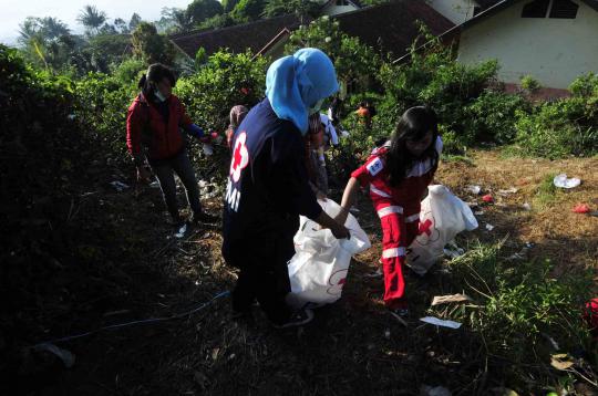 Relawan PMI dan TNI dibantu warga sekitar melakukan bersih   bersih di 