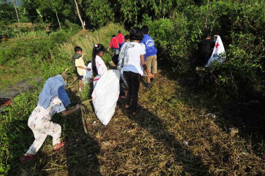 Relawan PMI dan TNI dibantu warga sekitar melakukan bersih   bersih di 