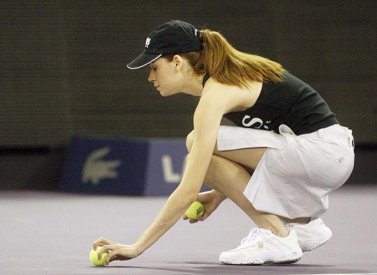 Gadis pemungut bola cantik di lapangan tenis